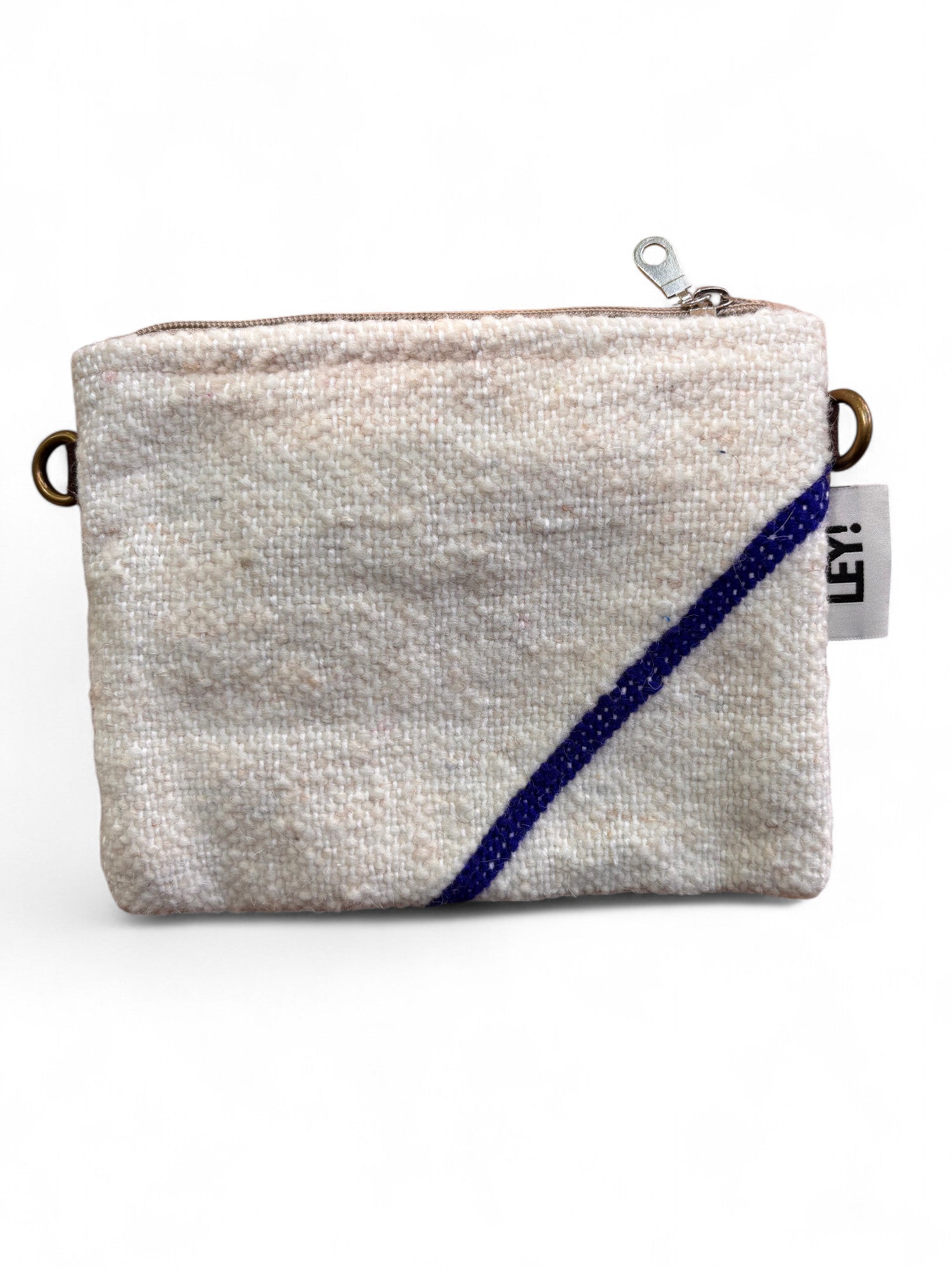 Eine kleine, rechteckige, strukturierte weiße Tasche (15x20cm) mit Reißverschluss, diagonalem blauen Streifen, Metallringen auf jeder Seite und einem weißen "LEY!"-Anhänger - eine Classic Line Tasche von LEY! aus Marrakesch.