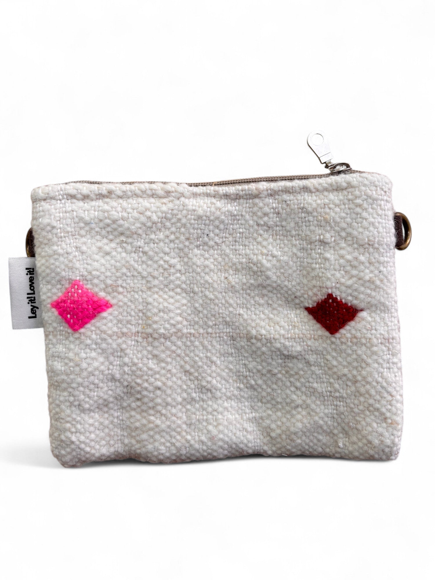 Die LEY! Tasche - Colorful Line - 15x20cm ist eine kleine, strukturierte weiße Wolltasche mit Reißverschluss, mit rosa und roten Rauten auf der Vorderseite, Details von Handarbeit Marrakesch, einem linken weißen Anhänger und einem Metallclip am Reißverschluss.