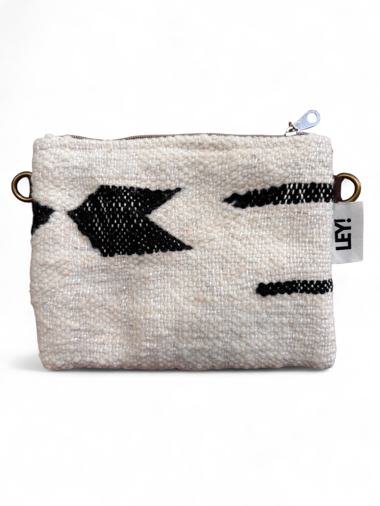 Die Tasche - Classic Line - 15x20cm von LEY! ist eine kleine, strukturierte, cremefarbene Stofftasche mit schwarzem, geometrischem Muster, einem Reißverschluss, Messingringen auf jeder Seite und einem weißen LEY!-Anhänger.