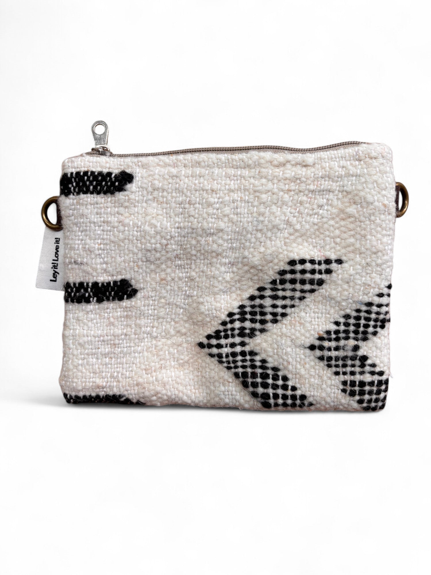 Die LEY! Tasche - Classic Line - 15x20cm ist eine kleine rechteckige Tasche mit weißem, strukturiertem Stoff und schwarzen, geometrischen Pfeilen, einem Reißverschluss an der Oberseite, seitlichen Metallringen und einem linken Stoffanhänger. Liebevoll handgefertigt in Marrakesch.