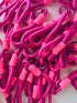 Eine Nahaufnahme von LEY! Schlüsselanhänger - pink zeigt ineinander verschlungene magentafarbene und pinkfarbene Spiralkordeln mit Kunststoffhaken - ideal als stylisches Accessoire für Schlüssel oder Taschen.