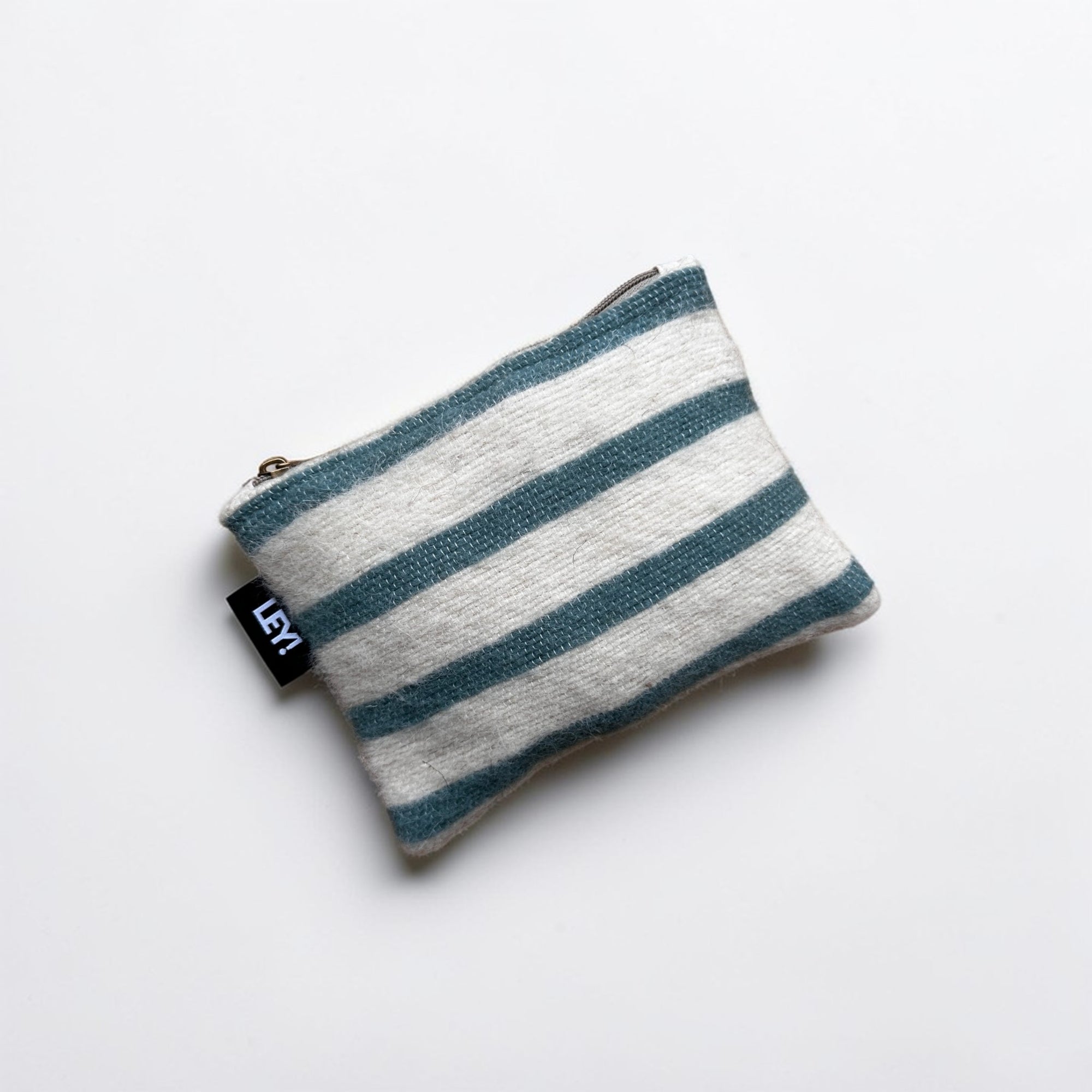 Die LEY! Tasche - WINTER EDITION - LAGUNE (15 x 20 cm) hat horizontale hellgraue und blaugrüne Streifen, einen Reißverschluss oben und ein schwarzes Seitenetikett mit weißem Text. Handgefertigtes Marrakesch-Flair, fotografiert auf weißem Hintergrund.