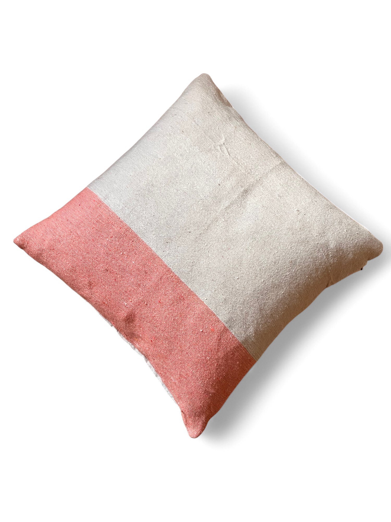 Das Kissen - Amela 60x60 von LEY! hat ein minimalistisches, quadratisches Design mit einer beigen Oberseite und einer korallenrosa Unterseite, handgefertigt in Marrakesch, und ist auf einem weißen Hintergrund abgebildet.