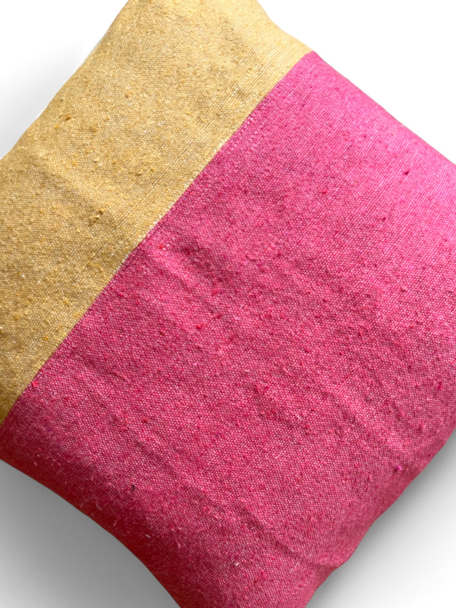 Eine Nahaufnahme des LEY! Kissen - Alinya 60x60 zeigt den Stoffbezug, der in hellbeige (oben links) und hellrosa (unten rechts) unterteilt ist. Dieses Spring Line Kissen wird vor einem weißen Hintergrund gezeigt.