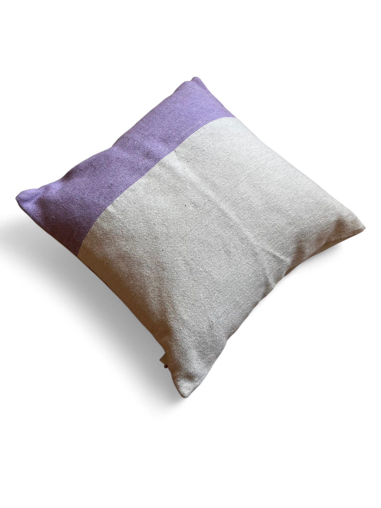 Das Kissen - Dilara 60x60 von LEY! hat ein zweifarbiges Design in Lila und Beige. Es ist handgefertigt und Teil der Spring Line. Es wird auf einem weißen Hintergrund mit einem weichen Schatten gezeigt.
