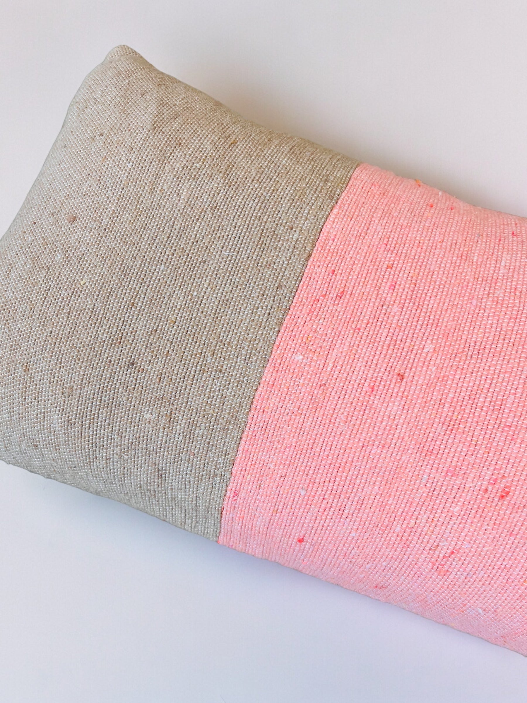 Das Kissen - Asma 30x50 von LEY! ist ein rechteckiges, handgefertigtes Kissen mit einem strukturierten Bezug in Hellbeige und Zartrosa aus der Spring Line, abgebildet vor einem schlichten weißen Hintergrund.