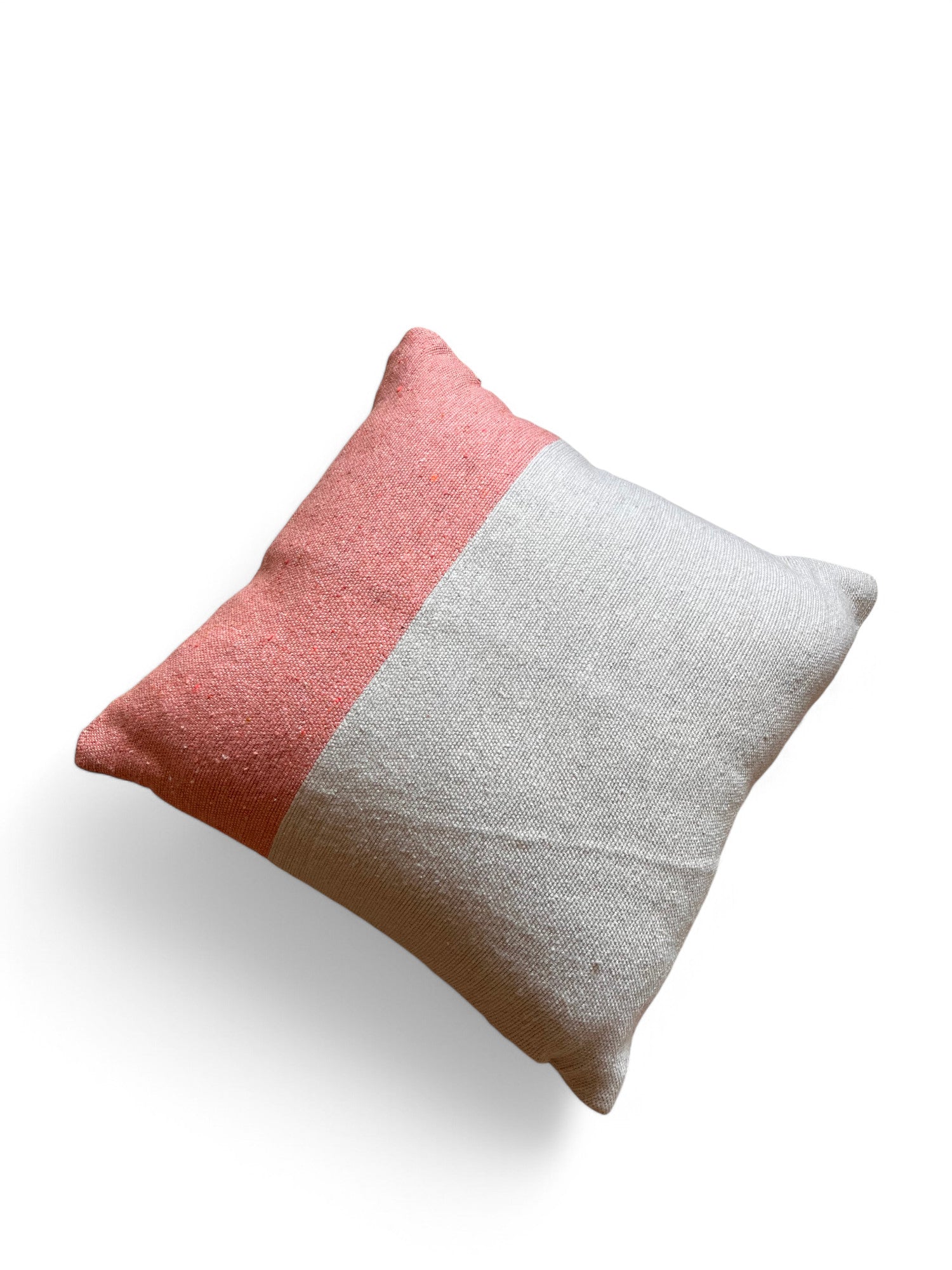 Das Kissen - Amela 40x40 von LEY! zeichnet sich durch ein einfaches zweifarbiges Design aus: gedämpftes Korallenrosa und strukturiertes Off-White auf weißem Hintergrund mit einem weichen Schatten.