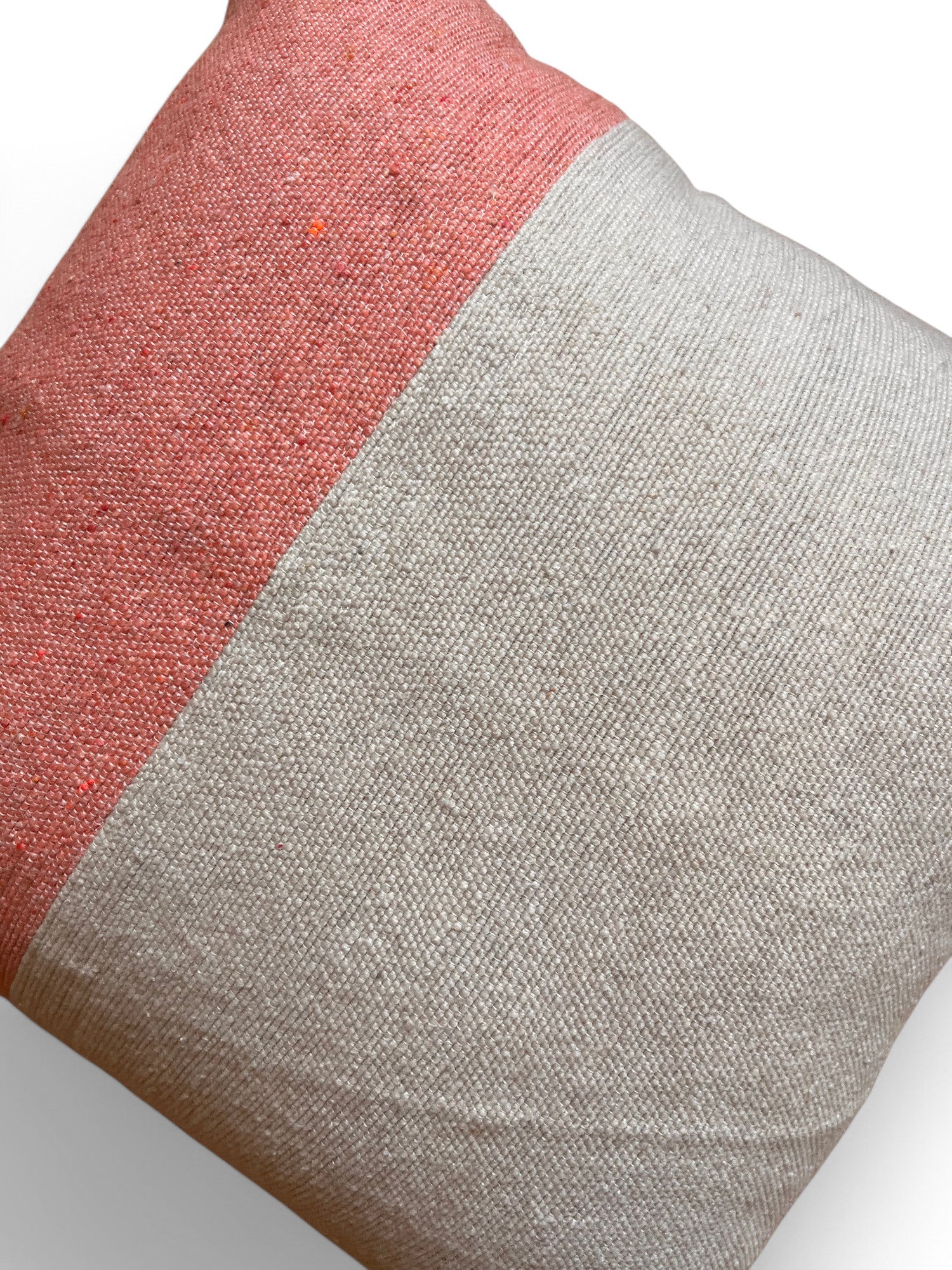 Das LEY! Kissen - Amela 40x40 ist ein quadratisches Wurfkissen mit einem handgefertigten Marrakesch-Farbblock-Design - korallenrosa und hellbeige strukturierter Stoff - auf einem knackigen weißen Hintergrund.