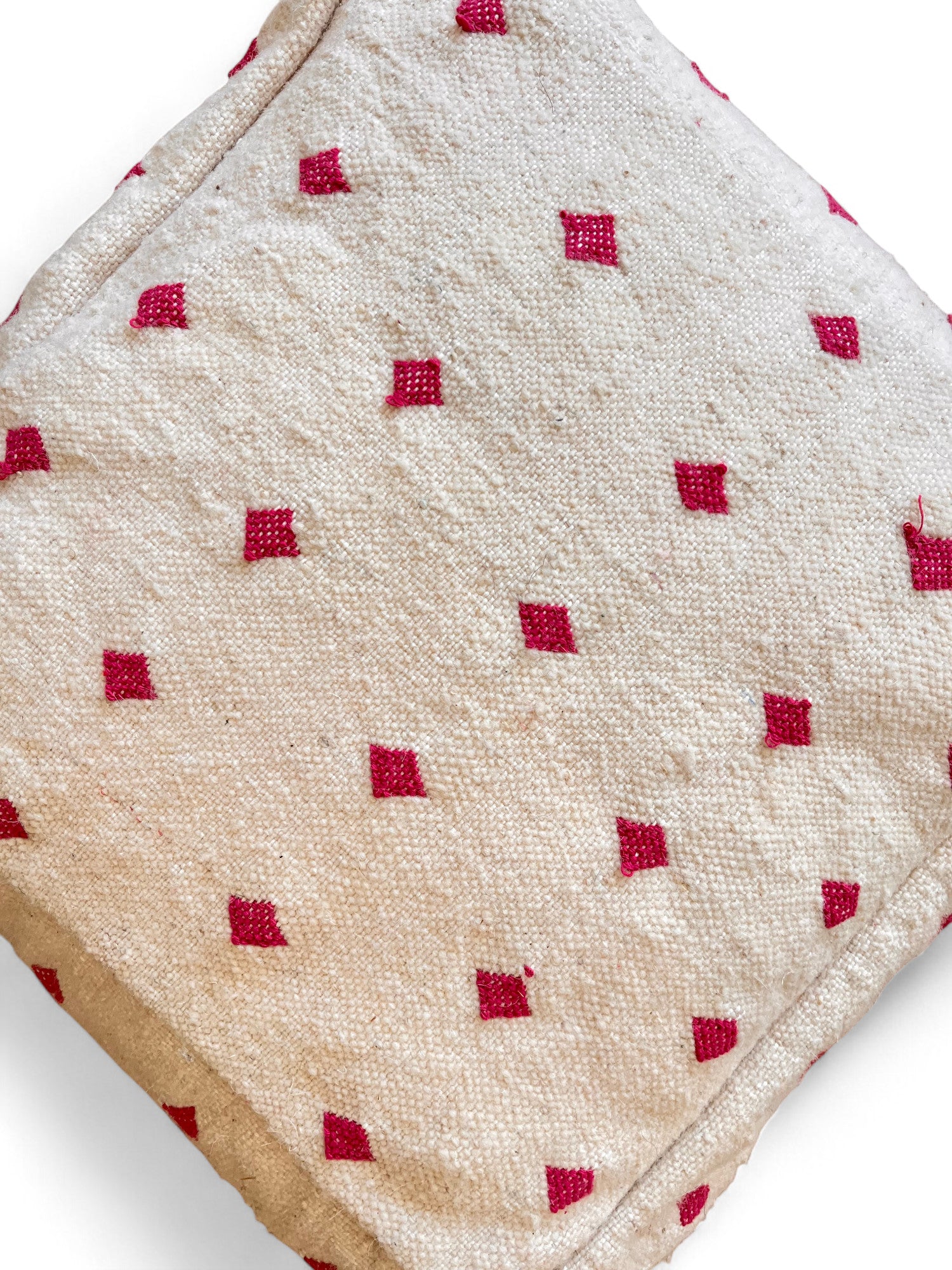 Die Abbildung zeigt das LEY! Kleines Bodenkissen - Mona Mini Lila, das im Marrakesch-Stil gefertigt wurde. Das Kissen hat eine weiche Schurwolle-Textur mit kleinen roten Rautenmustern, die auf weißem Hintergrund zu sehen sind.