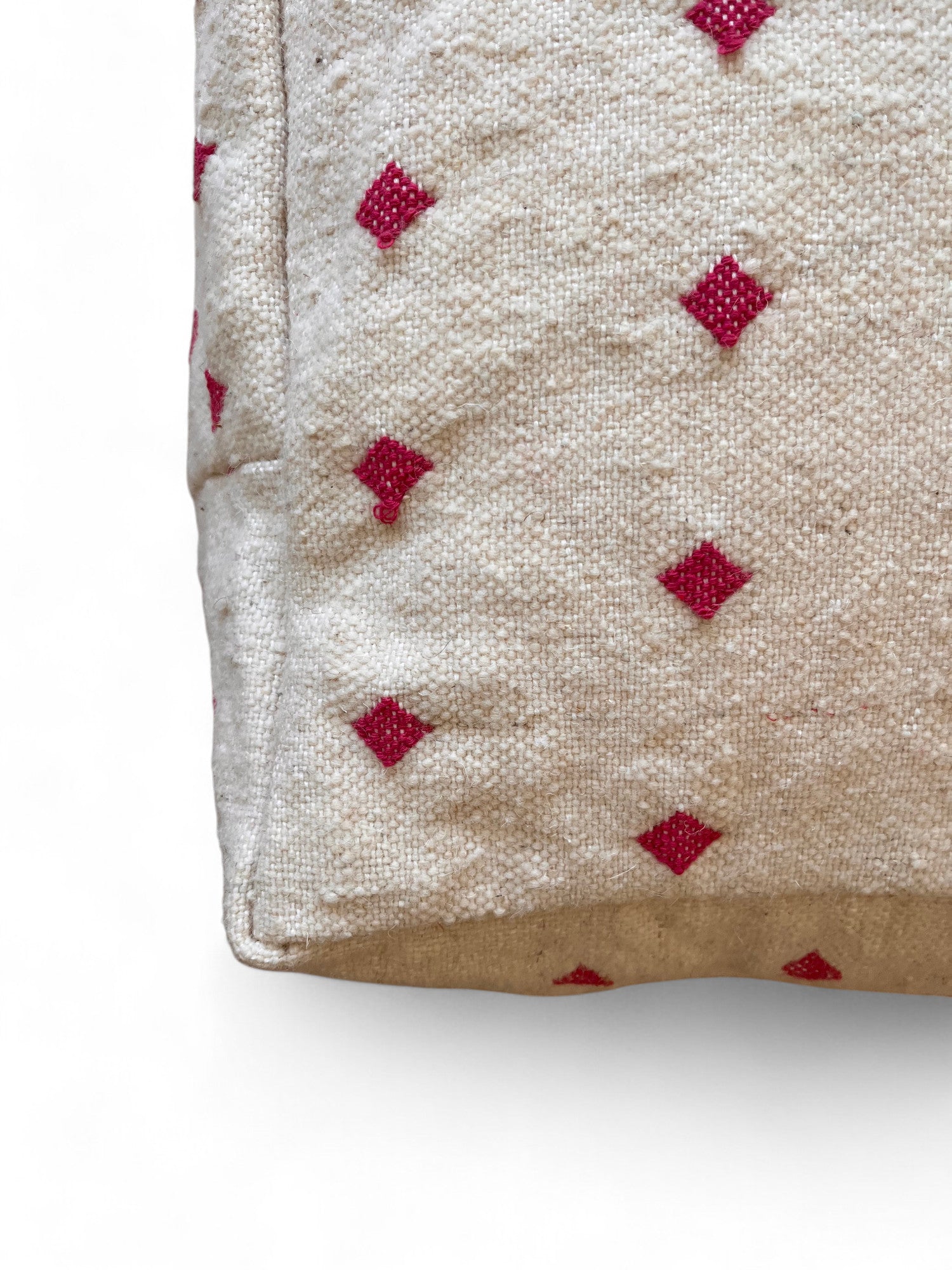 Nahaufnahme eines beigen Kleinen Bodenkissens - Mona Mini Lila von LEY! mit kleinen, hellrosa Rautenmustern, die die Ecken und Nähte hervorheben.