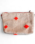 Die LEY! Tasche - Colorful Line - 20x30 ist eine beigefarbene, strukturierte Kosmetiktasche aus Schurwolle mit rotem Reißverschluss und vier leuchtend roten Diamanten auf der Vorderseite, die flach vor einem weißen Hintergrund abgebildet ist.