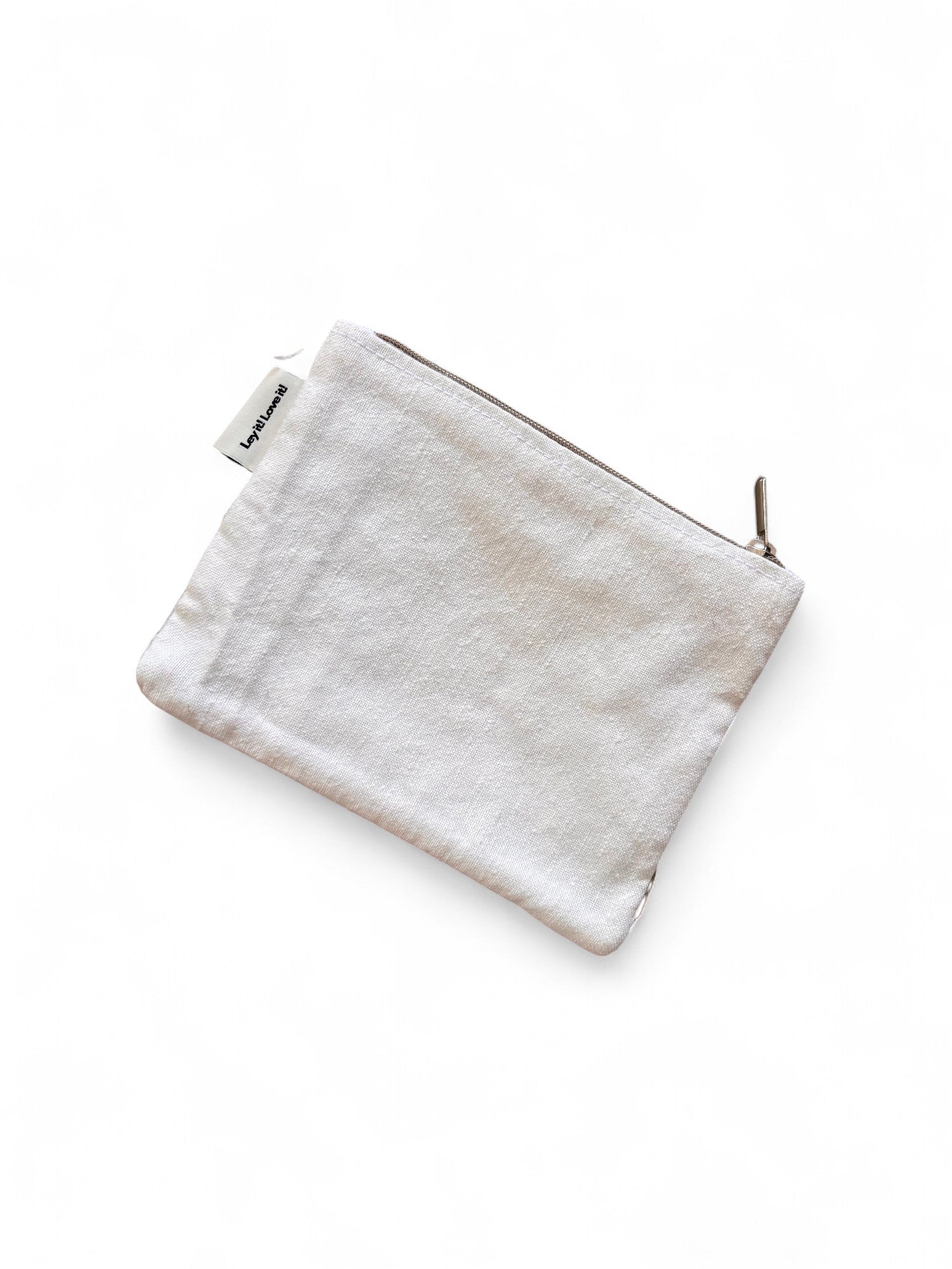 Diese hellbeige Stofftasche mit Reißverschluss, die LEY! Tasche - Colorful Line - 15x20cm, ist mit einem kleinen weißen Anhänger versehen und auf einem schlichten weißen Hintergrund fotografiert - ein ideales Alltags-Accessoire.