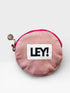 Der LEY! Coinholder - NUDE-PINK von LEY! ist ein kleiner, runder, pinker Stoffbeutel mit einem auffälligen "LEY!"-Aufnäher, einem pinkfarbenen Reißverschluss, einem Metallgriff und einem runden Anhänger. Dieses stylische Accessoire fungiert sowohl als Münzhalter als auch als Schlüsselanhänger.