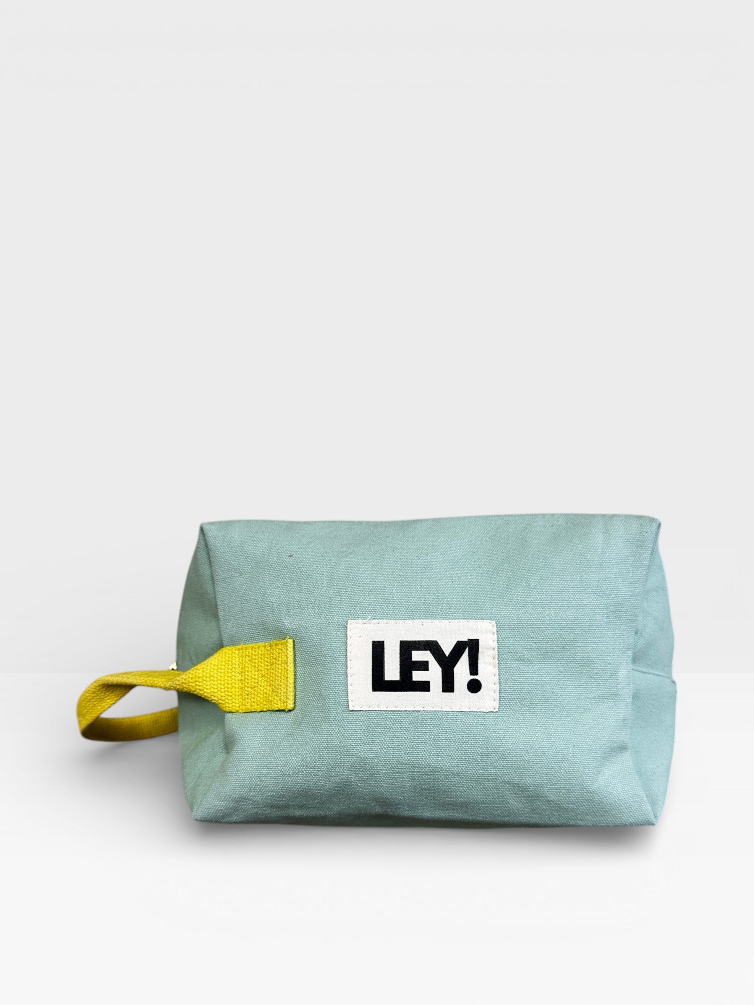 Die LEY! Pouch - MINT-GELB von LEY! zeichnet sich durch eine helle Teal-Farbe, einen gelben Seitenriemen und ein auffälliges "LEY!"-Label auf der Vorderseite aus - perfekt für ein Festival-Accessoire. Abgebildet vor einem schlichten weißen Hintergrund.