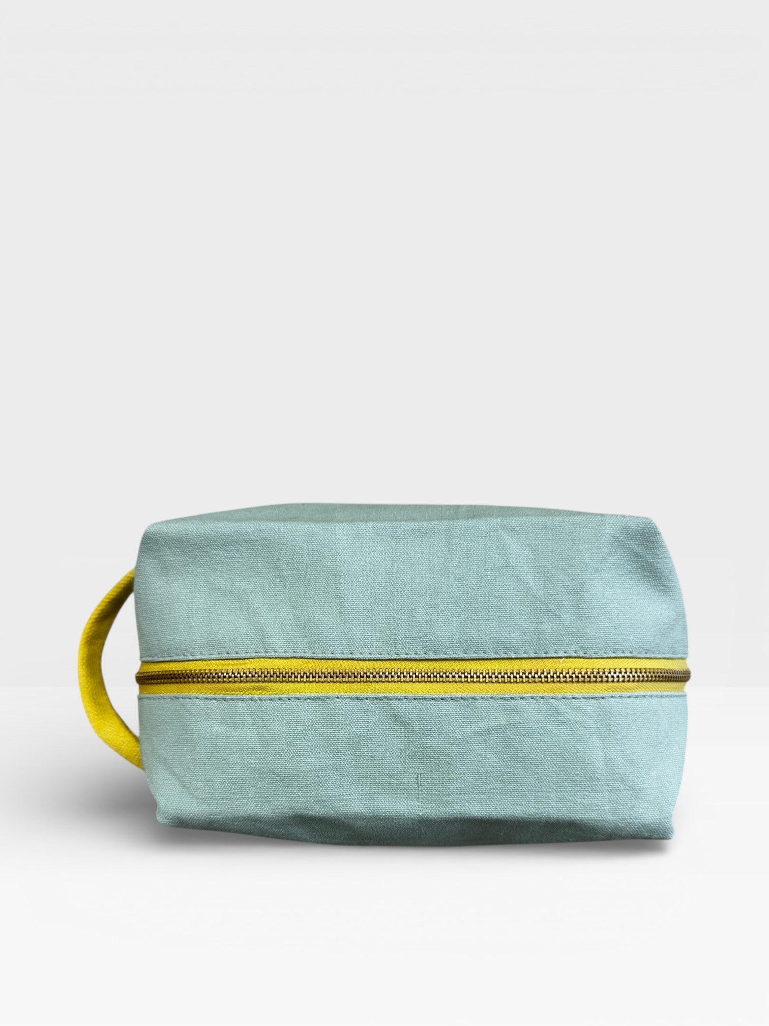 Der LEY! Pouch - MINT-GELB von LEY! hat eine mintblaue Farbe mit einem gelben Reißverschluss und Griff, ideal als Festival-Accessoire oder Reise-Toilettenbeutel, fotografiert auf einem schlichten weißen Hintergrund.