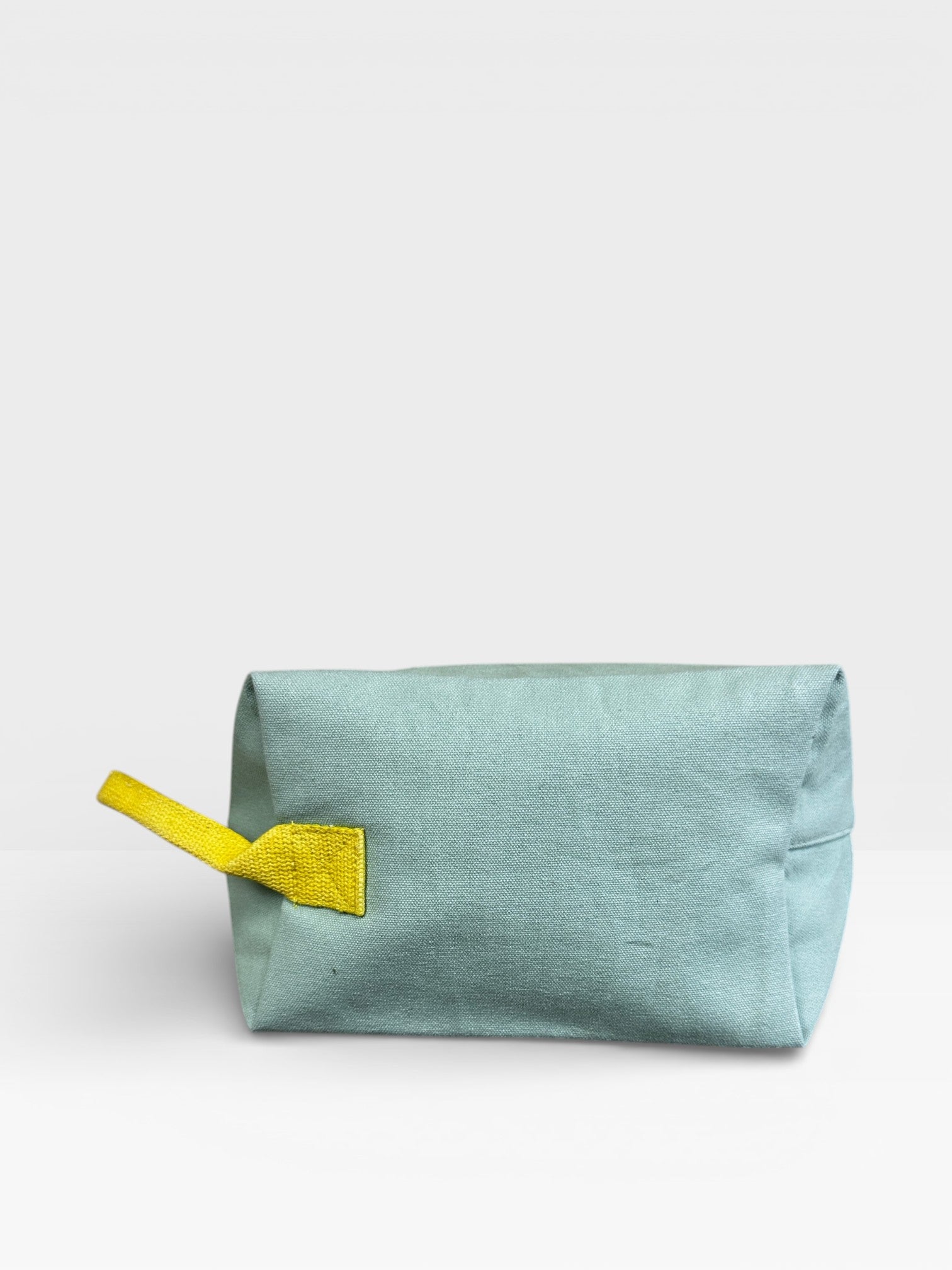 Der LEY! Pouch - MINT-GELB von LEY! ist ein rechteckiger mintfarbener Beutel mit gelbem Band, ideal als Kulturbeutel Reisen oder praktisches Festival-Accessoire, abgebildet auf einem schlichten weißen Hintergrund.
