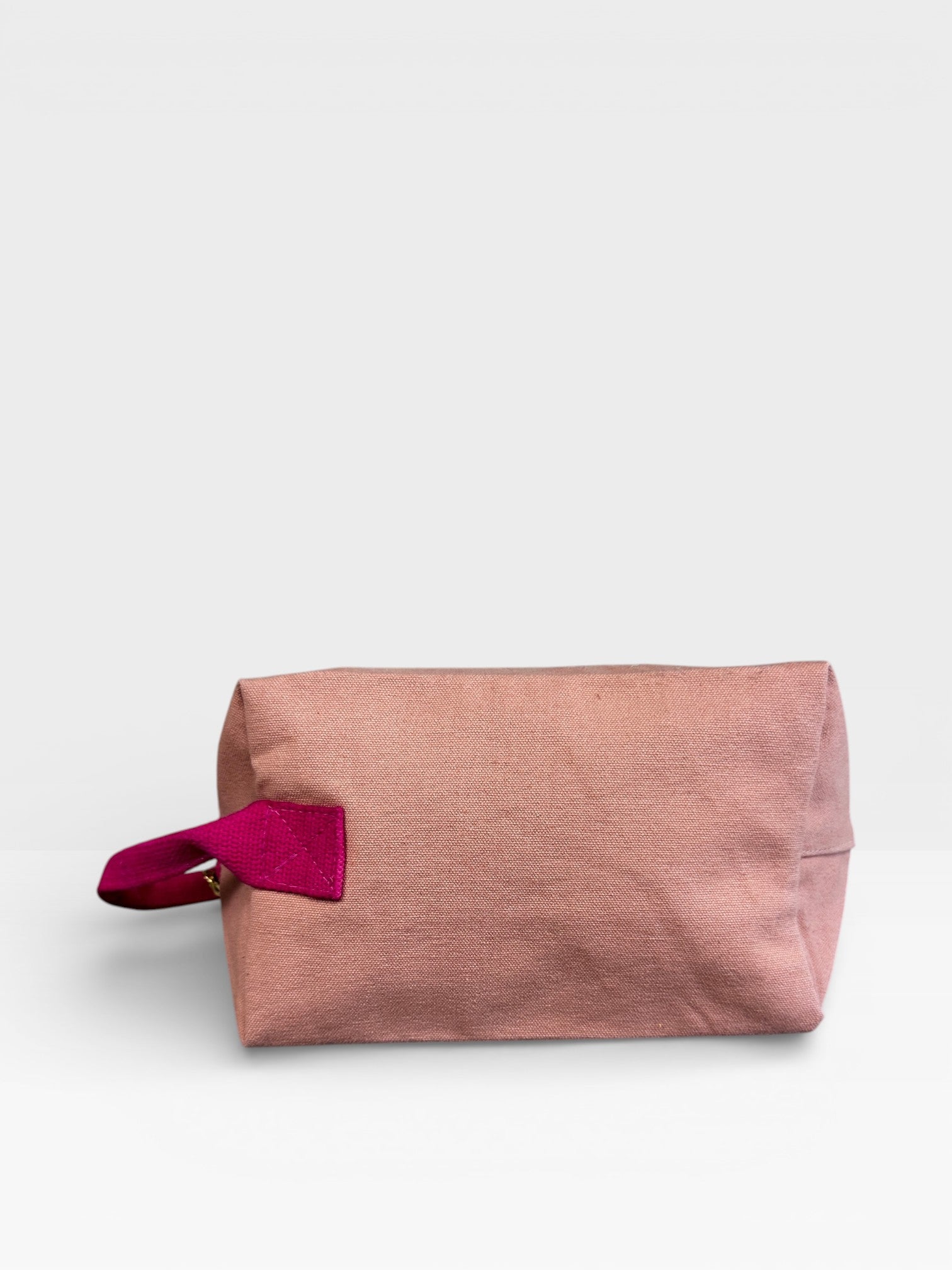 Die LEY! Pouch - NUDE-PINK von LEY! ist eine rechteckige, hellrosa Tasche mit einem leuchtend rosafarbenen Griff an der linken Seite, die auf weißem Hintergrund abgebildet ist - ideal als vielseitiges Festival-Accessoire.