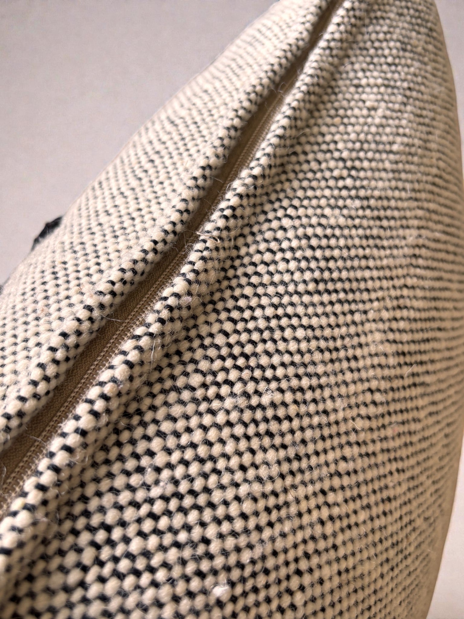 Nahaufnahme der Heritage Line Kissen von LEY! (50 x 50 cm), aus cremefarbenem Webstoff mit schwarzen Punkten und sichtbarem Reißverschluss - ideal als elegante Wohnaccessoires oder klassische Sofakissen für Ihr Zuhause.