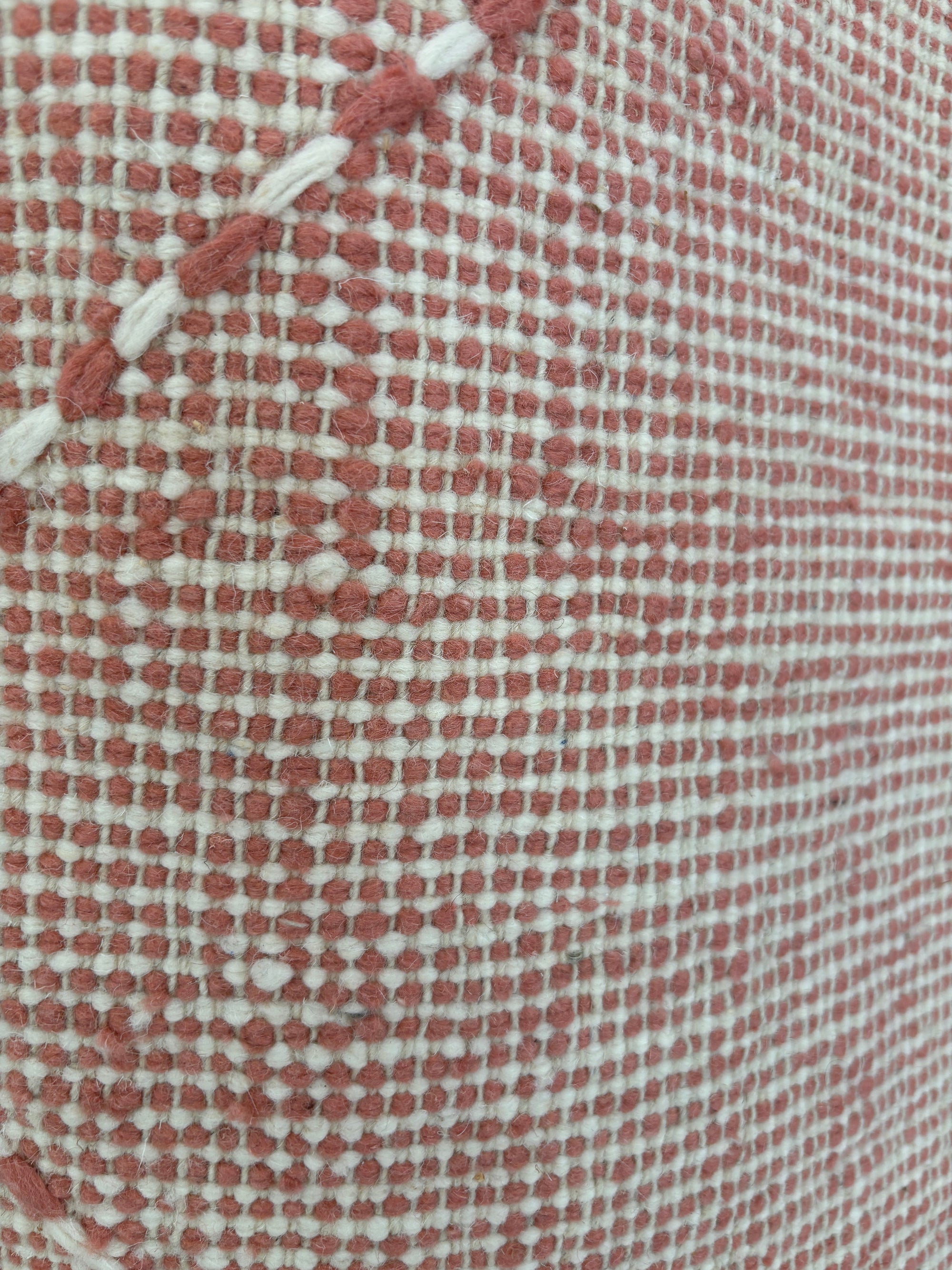 Die Nahaufnahme des LEY Teppichs - Ava (0,85 x 3,00) von LEY! zeigt sein rot-weiß kariertes Webmuster mit einer dicken weißen, diagonal gestickten Linie, die an traditionelle handgewebte marokkanische Teppiche erinnert.