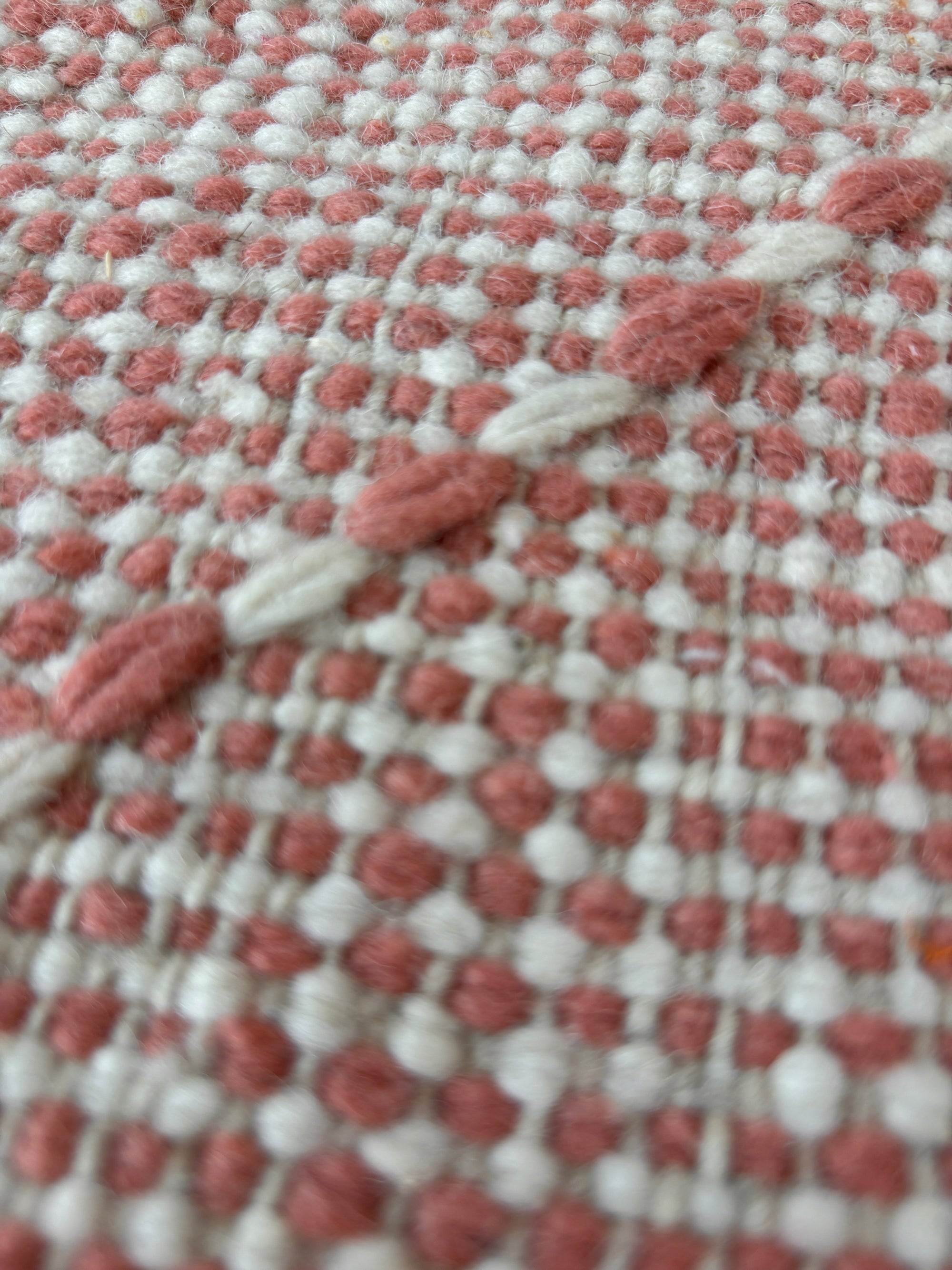 Nahaufnahme des LEY Teppichs - Ava by LEY!, 0,85 x 3,00: ein gewebtes Textil in Weiß und Staubrosa mit kleinen Punkten und erhabenen diagonalen Streifen, die an die weiche, leicht flauschige Haptik eines marokkanischen Teppichs erinnern.