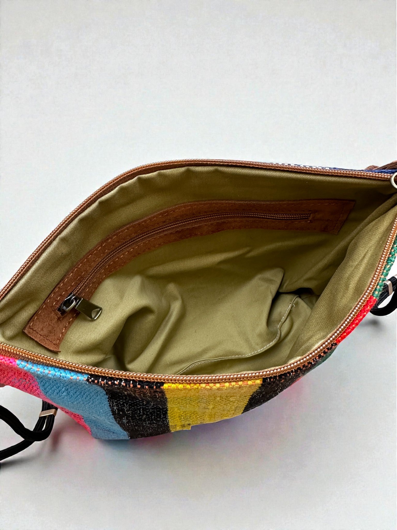 Die LEY! Tasche - OCULIA CLUTCH von LEY! aus buntem Vintage-Stoff besticht durch einen braunen Reißverschluss, tanfarbene Innenseite mit Zippertasche und braunen Details - die ideale handgefertigte Umhängetasche.
