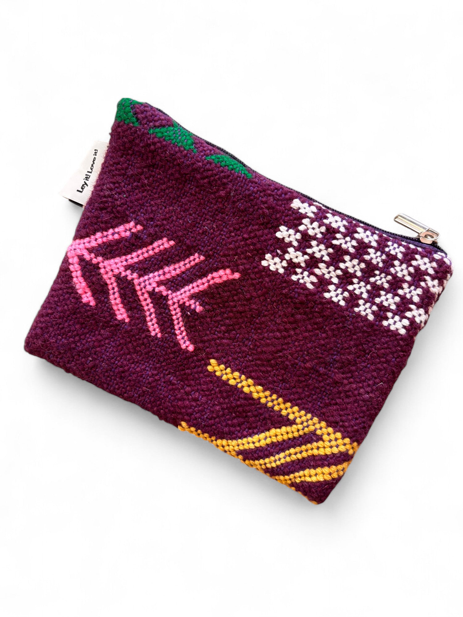 Die LEY! Tasche - Colorful Line - 15x20cm ist eine kleine Reißverschlusstasche aus strukturiertem dunkelviolettem Stoff mit rosa, gelben, weißen und grünen geometrischen Stickereien - ein elegantes handgefertigtes Stück aus Marrakesch.