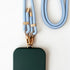 Ein grünes, rechteckiges Etui mit goldenem Verschluss ist an der LEY! Handykette - Hellblaues Schlüsselband mit goldener Hardware und "LEY!"-Schriftzug auf weißem Hintergrund.