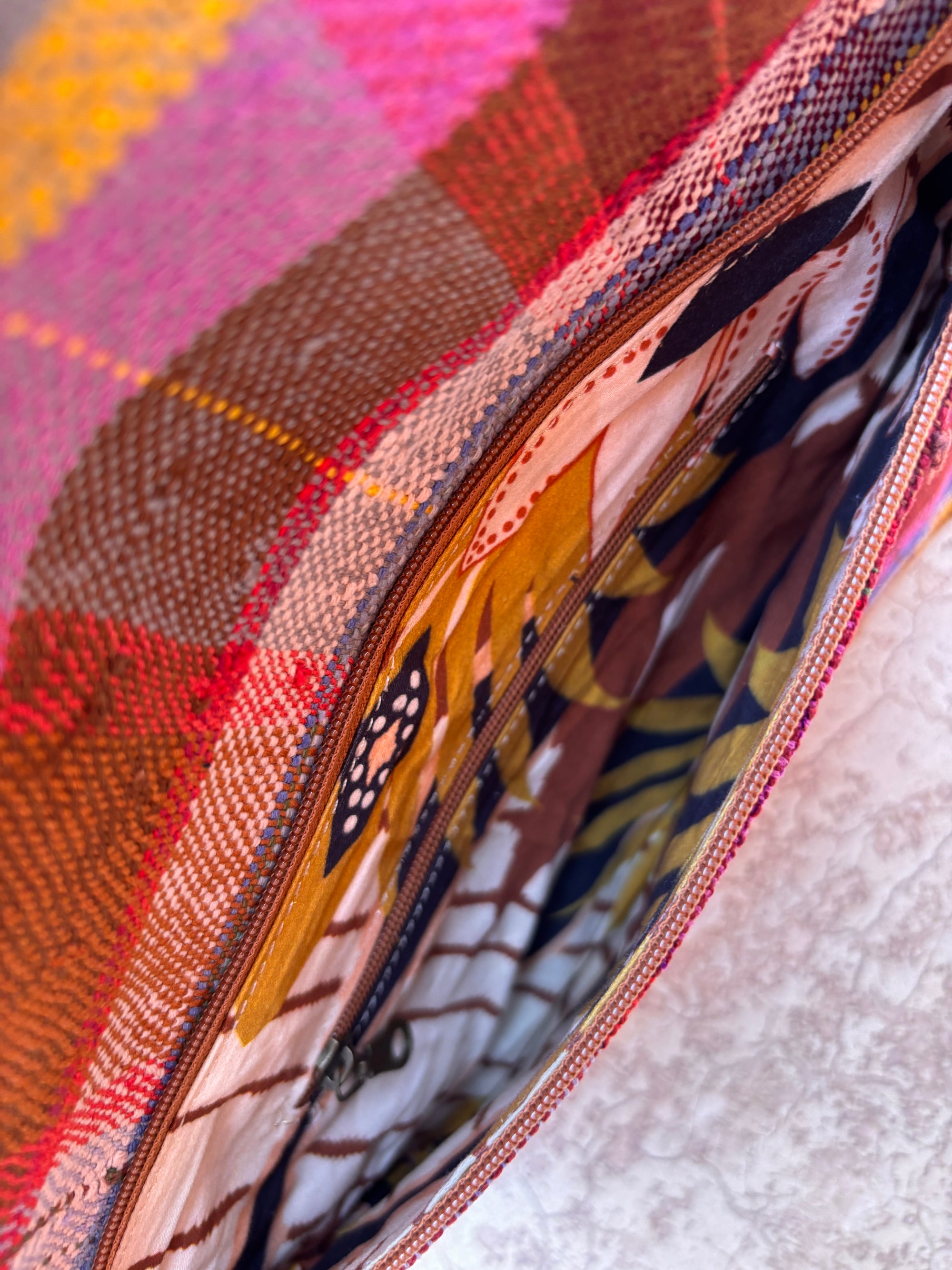 Nahaufnahme der LEY! Vintage Clutch, handgefertigt aus bunt karierter Wolle in Rosa, Orange und Braun, mit einem abstrakt gemusterten Futter in Braun, Schwarz, Weiß und Gold.