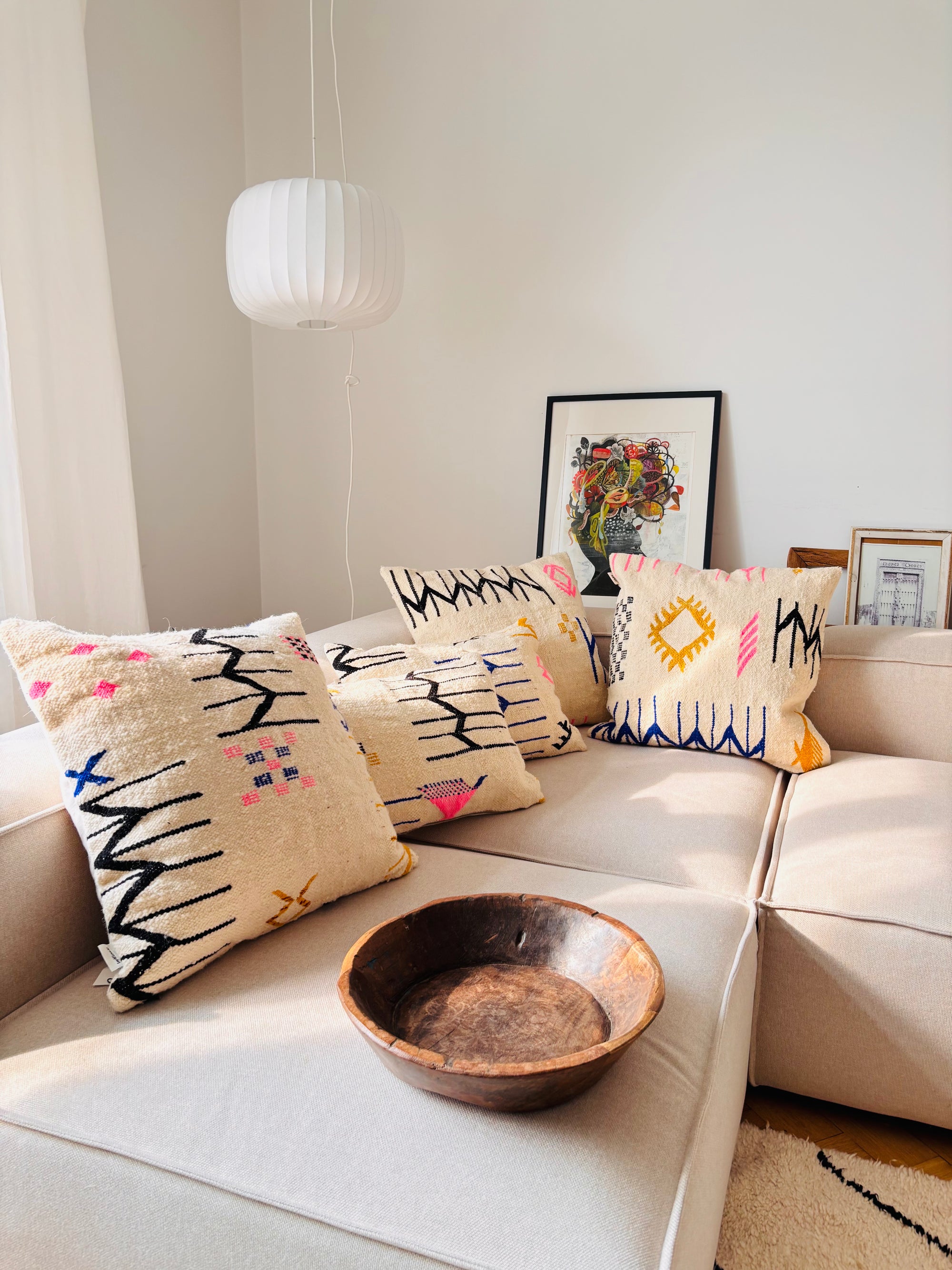 Marokkanische Wollkissen in verschiedenen Größen mit bunten Mustern auf beiger Couch