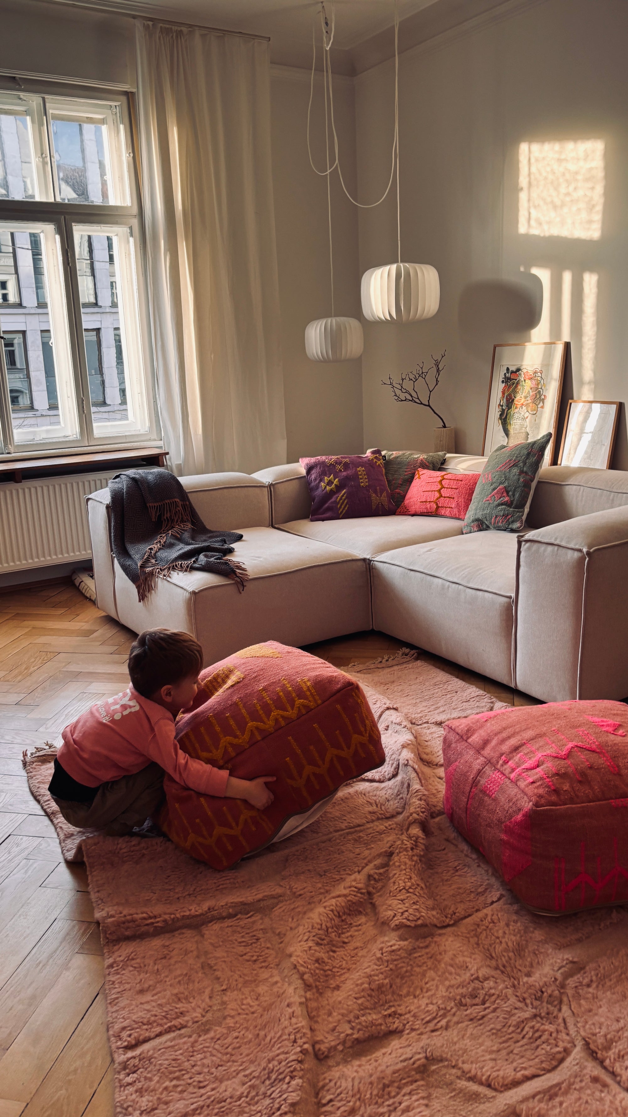 Bodenkissen auf kuschligem Teppich vor Sofa im Wohnzimmer 
