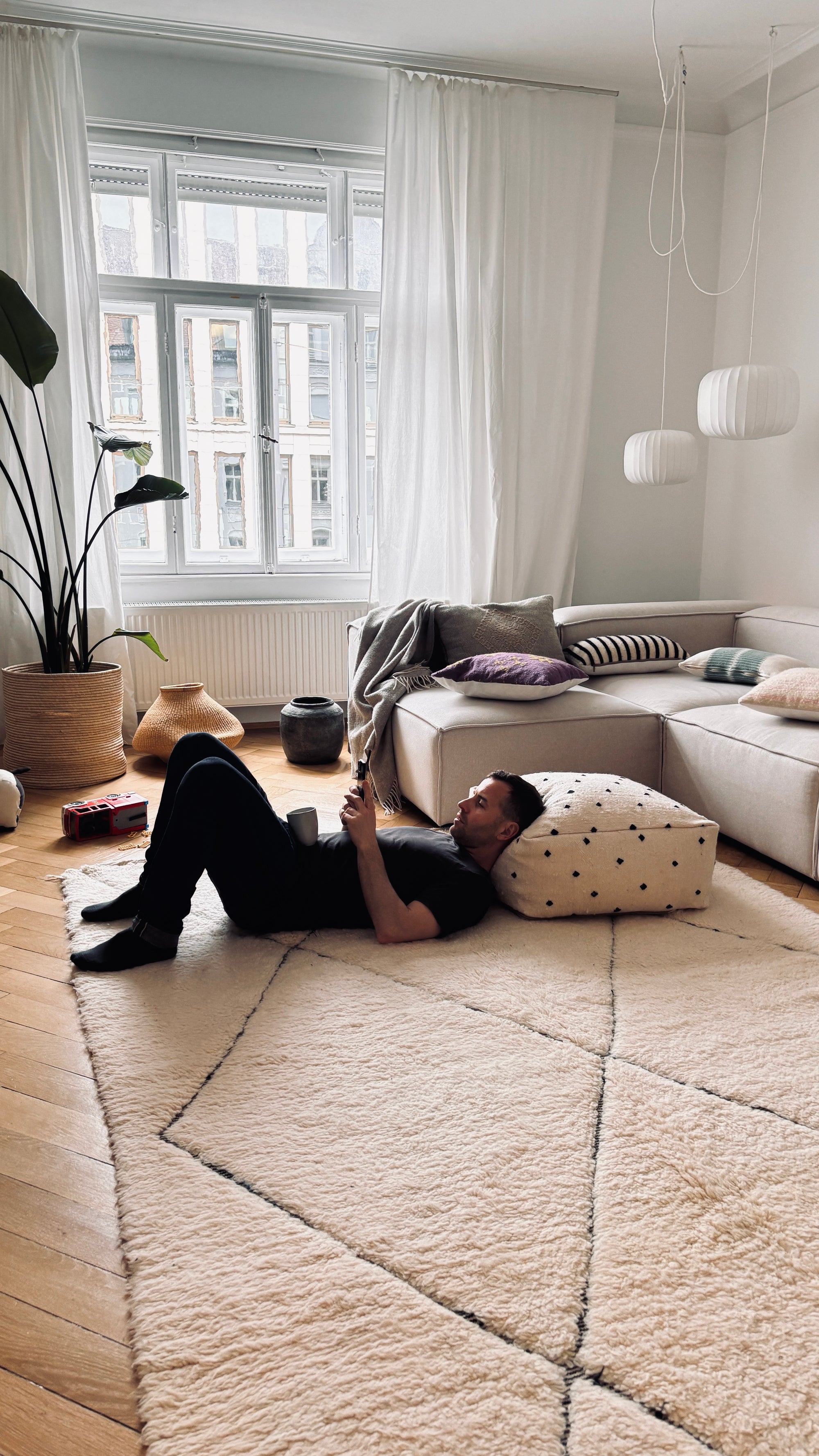 wohnzimmereinrichtung mit gemuetlichem bodenkissen vor sofa von westwing von ley