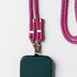 Eine grüne Handytasche ist an der LEY! Handykette - Pink - Rosa, ein rosa und weiß geflochtenes Schlüsselband mit goldenen Beschlägen auf weißem Hintergrund.
