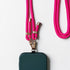 Eine dunkelgrüne Smartphone-Hülle ist auf der LEY! Handykette - Pink mit goldenen Akzenten und liegt auf einer weißen Oberfläche. Die Unterseite des Telefons ist auf dem Bild teilweise sichtbar.