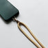 Eine dunkelgrüne Handytasche mit einem goldenen Clip ist an dem LEY! Schlüsselanhänger Beige Lanyard, alles auf einer weißen Fläche platziert.