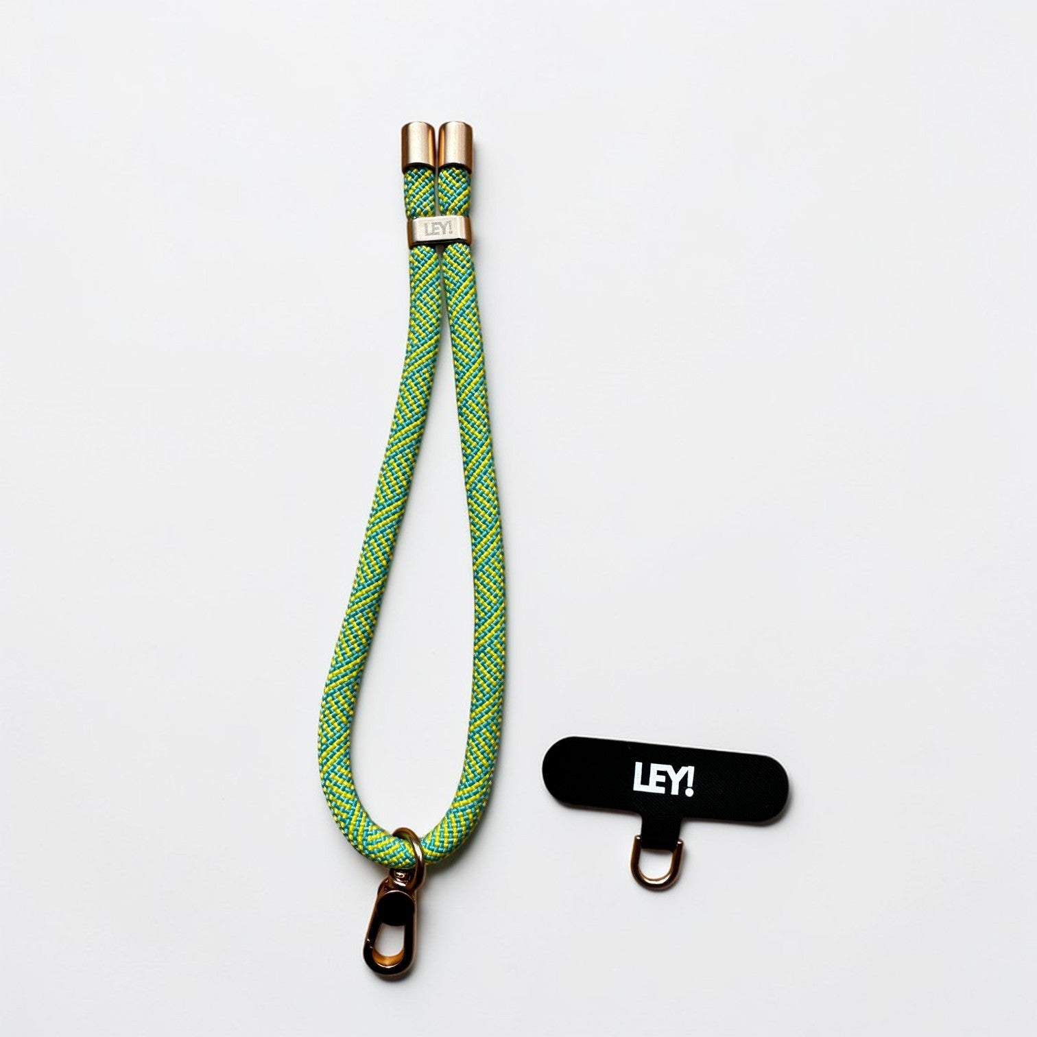 Ein gelber und türkisfarbener Schlüsselanhänger von LEY! mit goldenen Beschlägen wird zusammen mit einem schwarzen LEY! Wandhaken gezeigt - ideal, um ihn mit Ihrem Handy Zubehör oder Handyband für den täglichen Gebrauch zu kombinieren.